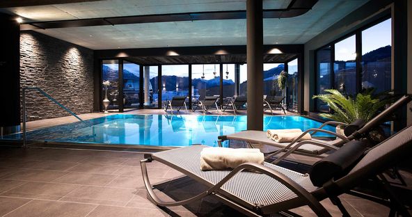 Der türkisblaue Indoor Pool im Wellnessbereich lädt zum Abtauchen ein.